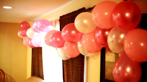 Blow up varying shades of your color and tie them to a long ribbon to make an arch!