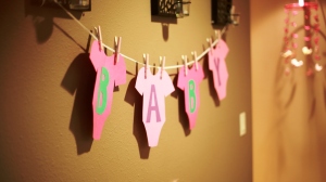 Cut out the shape of a Onesie and letters to make a banner! Use Clothespins to attached to ribbon. 